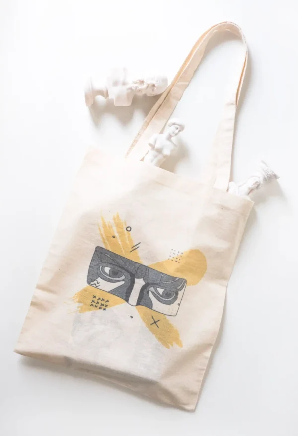 Cotton tote bag with artistic face illustration and decorative sculpture props