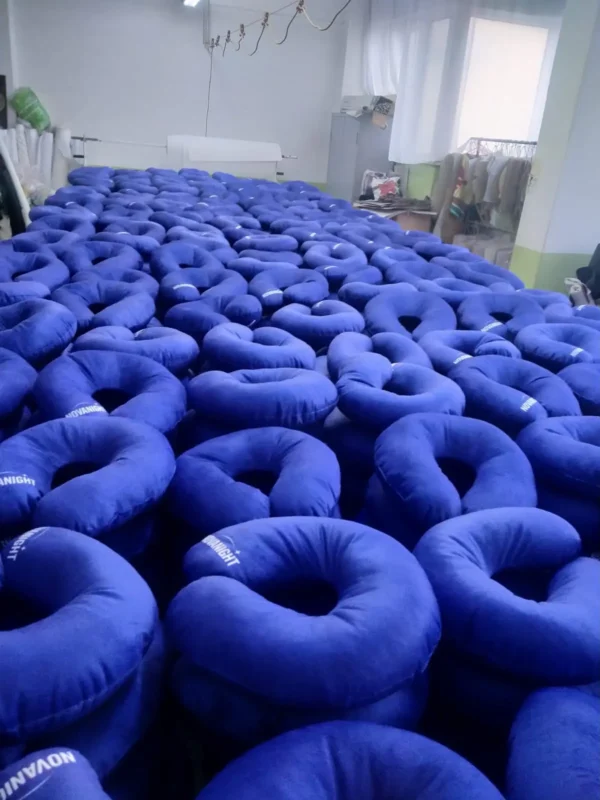 Mass production of blue branded travel pillows in textile workshop – Textile Promos
