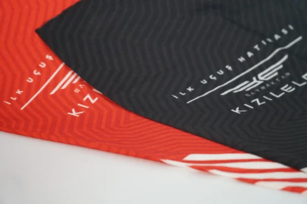 Close-up detail of black and red branded promotional buffs – Textile Promos