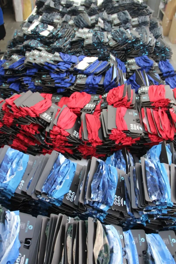 Large batch of colorful custom buff headwear with branded packaging