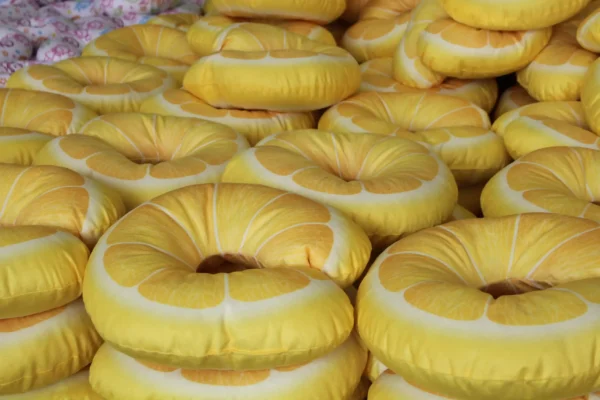 Bulk display of yellow fruit slice themed travel pillows – Textile Promos