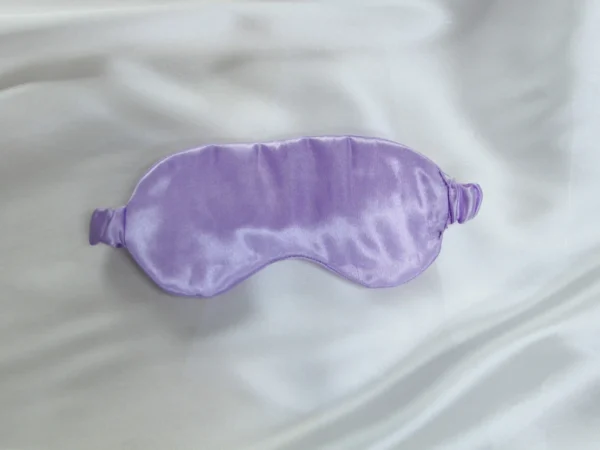 Lavender satin sleep mask on white satin background