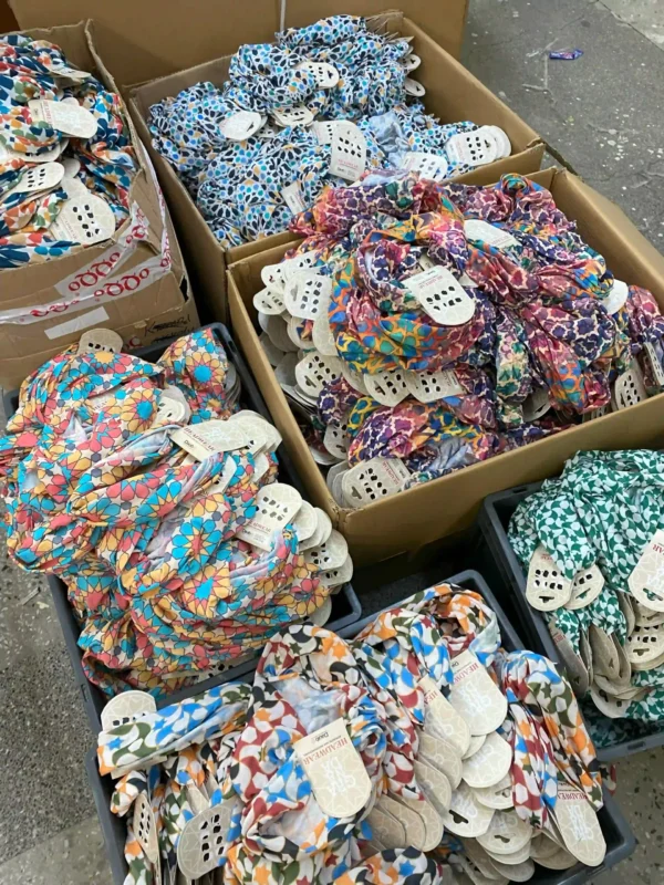 Various colorful printed buff products neatly packed in boxes, ready for shipment in a textile production facility