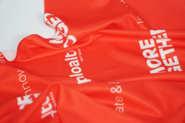 Fabric texture close-up of red branded bandana – Textile Promos