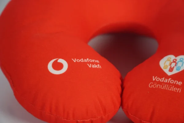 Close-up of custom logo printing on red travel neck pillow – Textile Promos