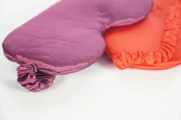 Detail close-up of two satin sleep masks with custom branding – Textile Promos