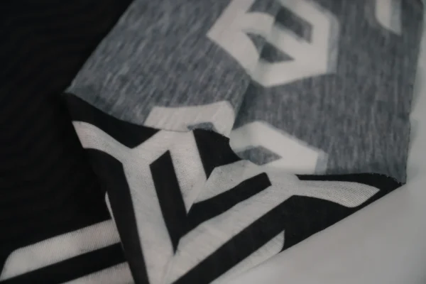 Seamless black branded buff – construction and logo detail by Textile Promos