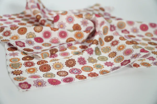 Close-up of vivid patterned square scarf in folded form – Textile Promos