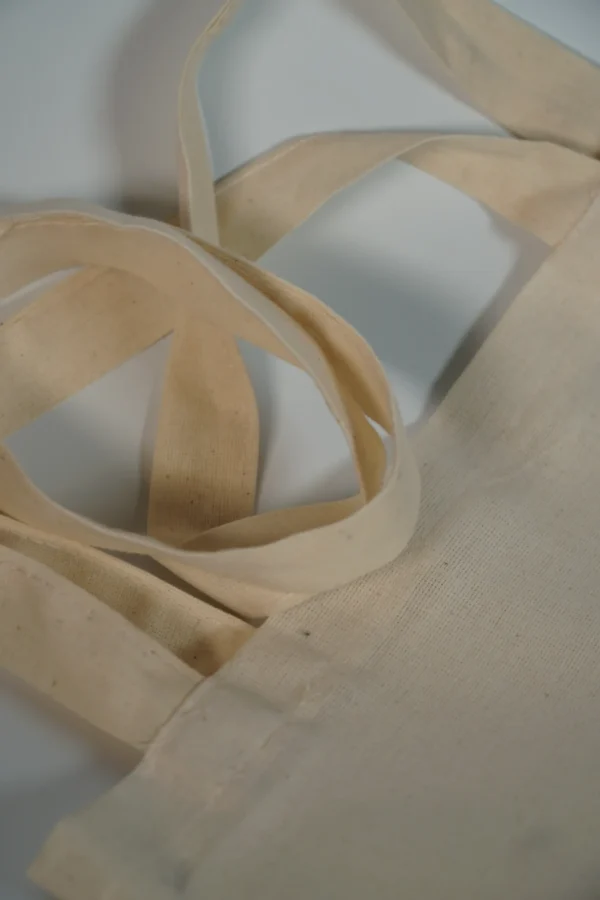 Close-up of tote bag handles and stitching on natural cotton – Textile Promos